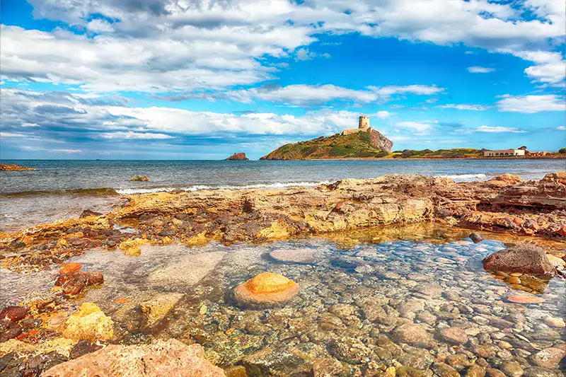 Nora, un panorama côtier historique en Sardaigne Paysage côtier de Nora avec une tour ancienne en Sardaigne