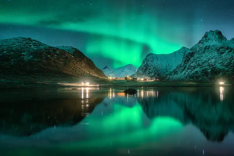 Aurores boréales aux îles Lofoten Aurores boréales dans le ciel nocturne des îles Lofoten, se reflétant sur l'eau