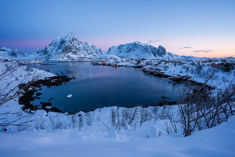Paysage hivernal des îles Lofoten Paysage hivernal des îles Lofoten avec des maisons rouges et des montagnes enneigées