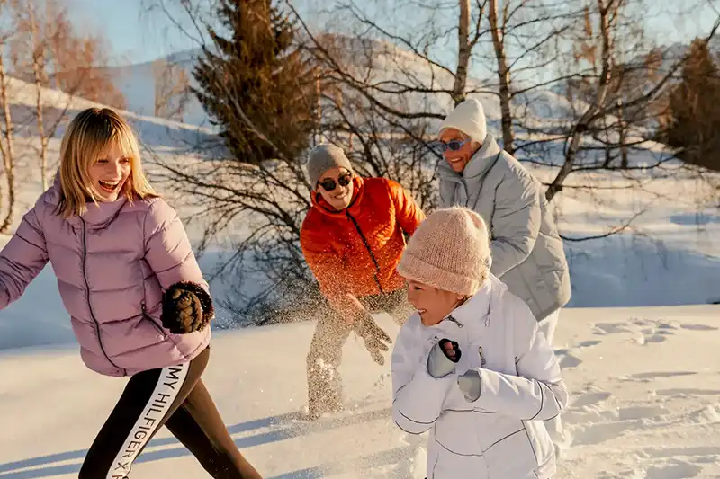 Famille profitant de la neige et s’amusant en hiver