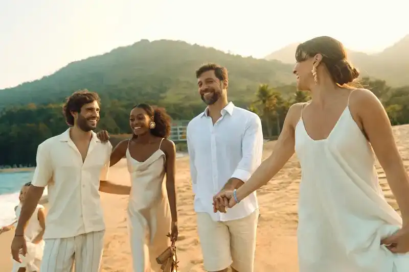 Groupe d’amis marchant sur la plage au coucher du soleil