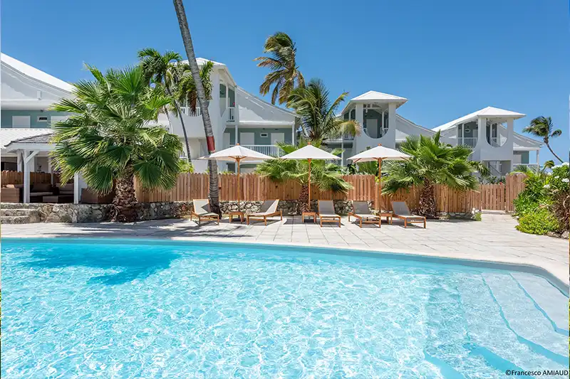 Hôtel avec piscine à Saint-Martin Hôtel à Saint-Martin avec piscine extérieure et transats sous les palmiers