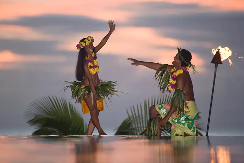 Danse tahitienne – Soirée traditionnelle en Polynésie Danseurs polynésiens en tenue traditionnelle au coucher du soleil