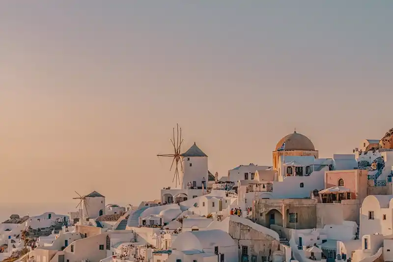 Panorama de Santorin au coucher du soleil avec les maisons blanches et le moulin emblématique