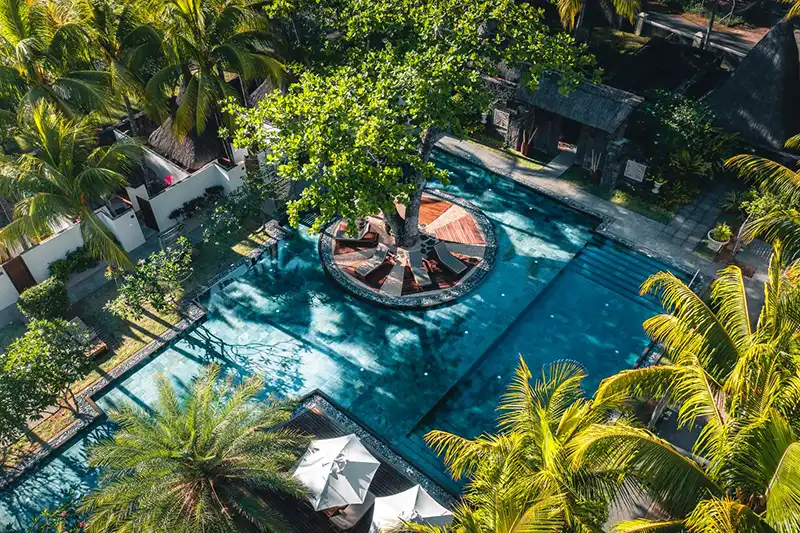 Piscine d’un hôtel Beachcomber entourée de palmiers à l’île Maurice