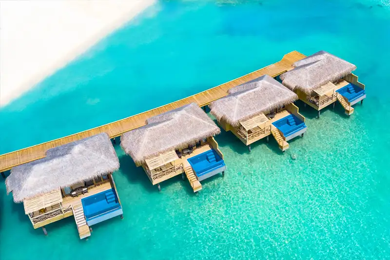 Villas sur pilotis au You & Me Maldives dans un lagon turquoise