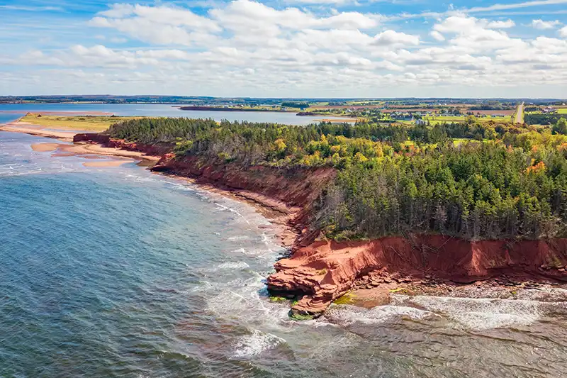 Falaises de grès rouge bordées de forêts sur le littoral de l’Île-du-Prince-Édouard, au Canada