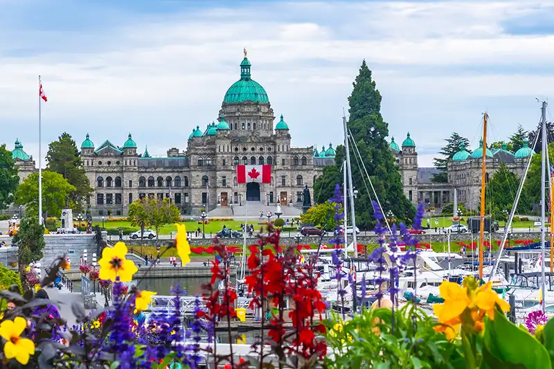 Parlement de Colombie-Britannique à Victoria, avec voiliers et fleurs au premier plan