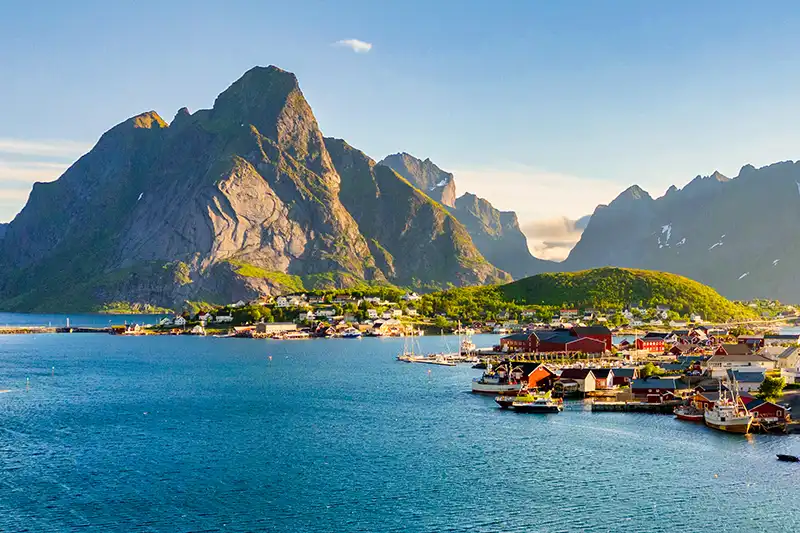 Village des îles Lofoten entouré de montagnes au bord de l’eau, en Norvège