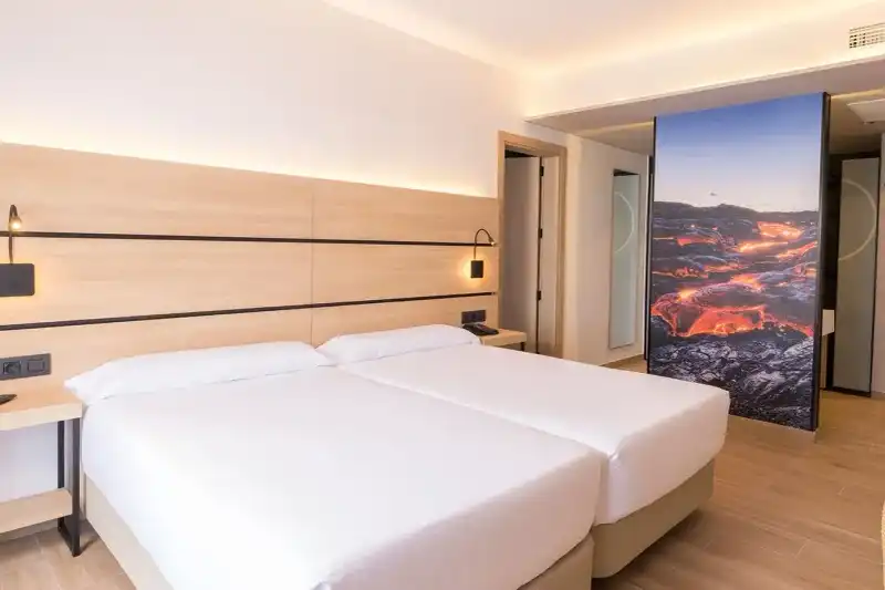 Chambre lumineuse aux lits jumeaux et décoration contemporaine dans un hôtel à Lanzarote.